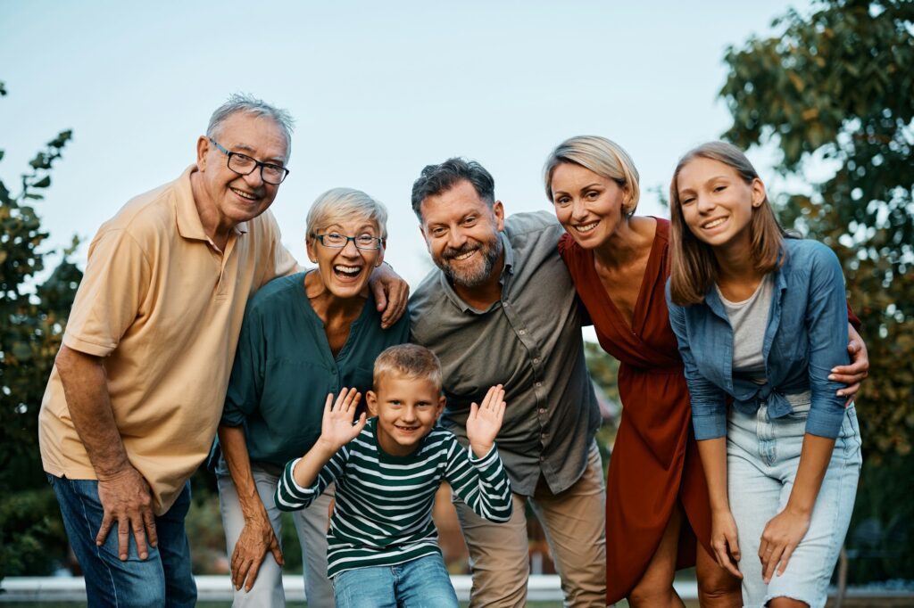 Cheerful multigeneration family in nature looking at camera.